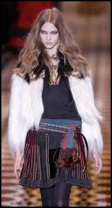 Gucci - Near left - black and white goat pleated jacket with leather trim detail, black wool linen multi-ribbon embroidered skirt and sequoia and brown silk scarf with tassels. 