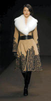 Embroidered camel hair coat with white fox collar.