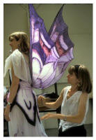 Shirley adjusts the wings of a costume.