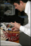 Backstage finishing of garment, a Giambattista Valli fashion design with Swarovski crystals. 
