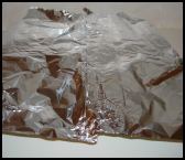 Cover the basin and paper with a pleated sheet of foil.  This allows for any rising of the pudding.